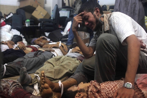 A man grieved as he looked at one of many bodies laid out in a make shift morgue after Egyptian security forces stormed two huge protest camps at the Raba'a al Adiwiya and Nahda squares Wednesday.