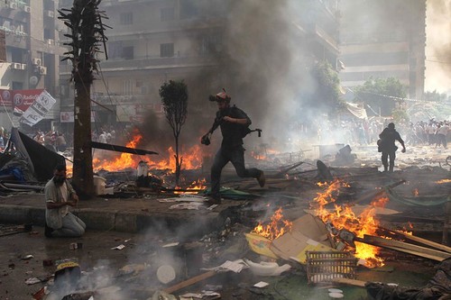 Major roads were closed and tanks lined the streets as the government braced for a reaction from Muslim Brotherhood supporters. Above, reporters ran for cover during clashes.