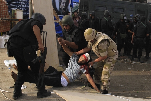 Police carried an injured member of the Muslim Brotherhood and Morsi supporter in Raba'a al Adiwiya square after troops cleared two antigovernment sit-ins in Cairo Wednesday morning.