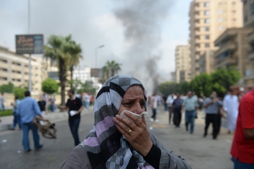 Security forces fired tear gas and live ammunition at unarmed protesters including women. Here, a woman protected her face from tear gas.
