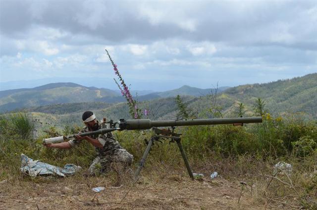 Cảnh một chiến binh thuộc phe nổi dậy đang phóng tên lửa gần cảng Latakia, Syria
