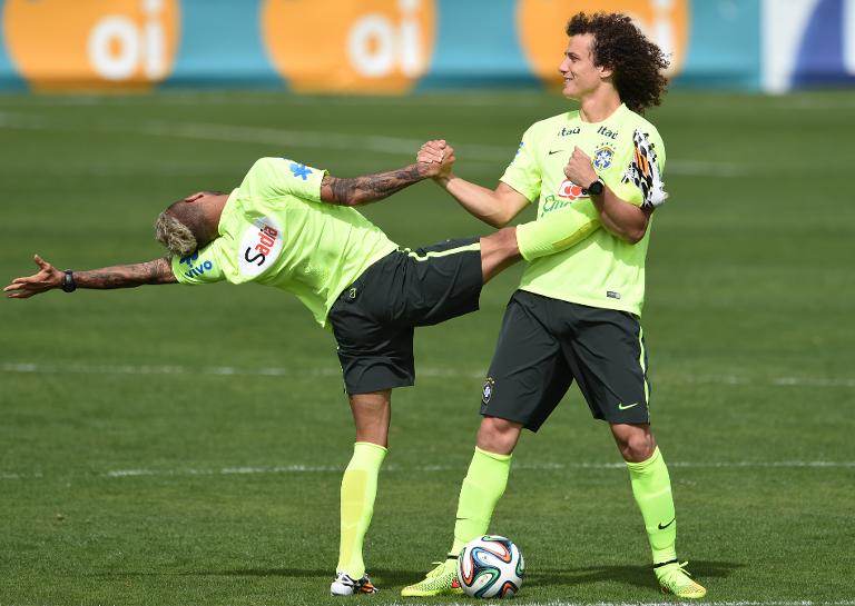 Hậu vệ của Brazil David Luiz (R) giúp hậu vệ Dani Alves luyện tập tại khu huấn luyện Granja Comary tại  Teresópolis,  Rio de Janeiro,  Brasil
