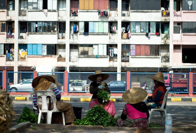 Những người phụ nữ Malaysia sắp xếp những đống rau bên ngoài một khu chợ bán buôn tại thủ đô Kuala Lumpur