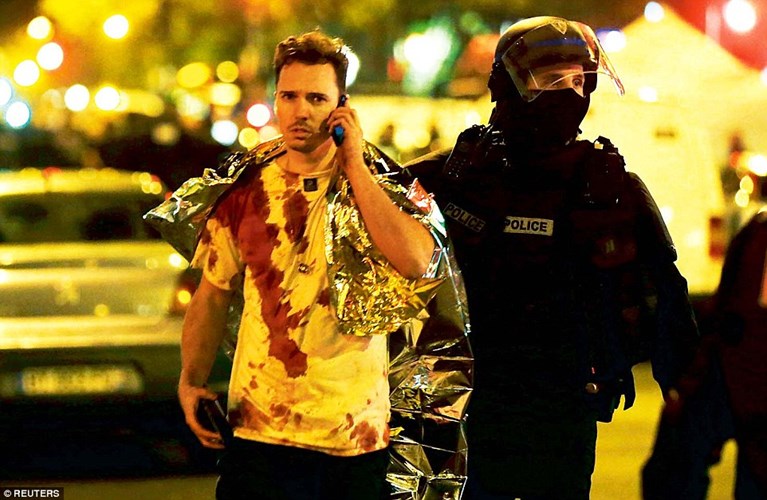 Nhiều khán giả ở nhà hát Bataclan, Paris hôm ấy có lẽ sẽ không bao giờ quên được cảnh tượng kinh hoàng khi các tay súng IS xông vào và nã đạn. Một nhân chứng trong vụ thảm sát nhà hát Bataclan bước ra ngoài và trên người dính đầy máu. (ảnh: Reuters)
