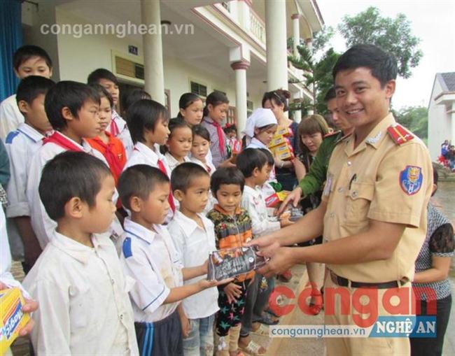 Các thành viên trong đoàn trao quà  cho các em học sinh