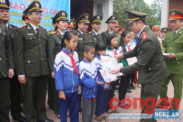 Đồng chí Thượng úy Hoàng Lê Anh- Bí thư Đoàn Công an tỉnh Nghệ An, đại diện Cụm thi đua trao quà cho học sinh Nam Trung, Nam Đàn