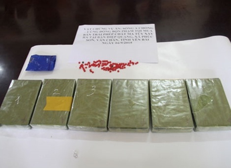 Tang vật vụ án (14 bánh heroin, 4.000 viên hồng phiến).