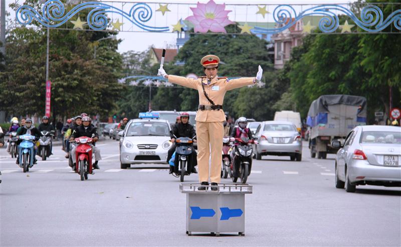 Nữ CSGT hướng dẫn phân luồng giao thông tại ngã tư đường phố
