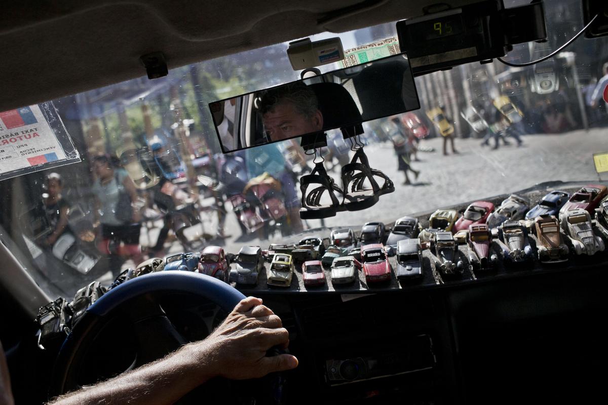 Xe mô hình được đặt kín trên táp-lô xe của tài xế taxi Roman Donoso khi anh đang chay trên các con phố ở trung tâm Santiago, Chile, 22/02/2016.