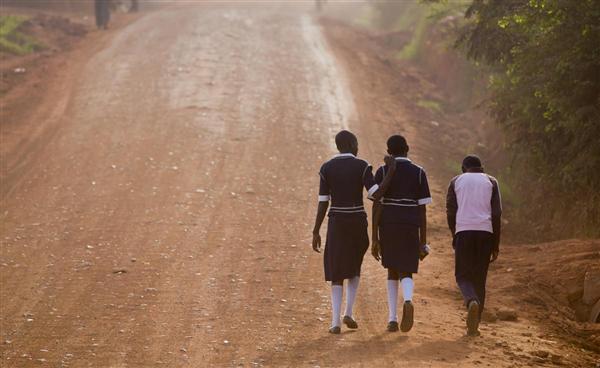Trẻ em Uganda đi bộ trên những con đường đất bụi bặm để đến trường vào buổi sáng trong ngày đầu tiên của học kỳ mới, ở Kasangati, gần Kampala, 22/02/2016.