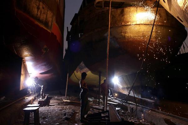 Các công nhân người Bangladesh đang sửa chữa một con tàu lớn tại xưởng đóng tàu bên bờ sông Buriganga, Dhaka, 18/02/2016.