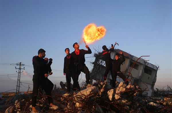 Thanh niên Palestine, các thành viên của câu lạc bộ võ thuật Gazan, trình diễn màn thổi lửa tại một căn nhà đổ nát ở Beit Hanoun, phía Bắc Dải Gaza, 11/02/2016.
