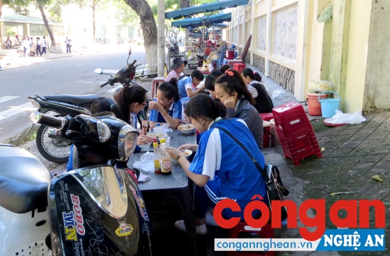Học sinh vô tư ăn uống trước cổng trường mà không quan tâm đến vấn đề VSATTP