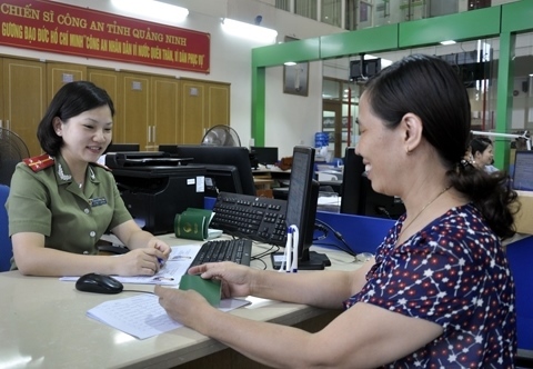 Nữ chiến sỹ CAND vui vẻ giúp nhân dân làm thủ tục hành chính.