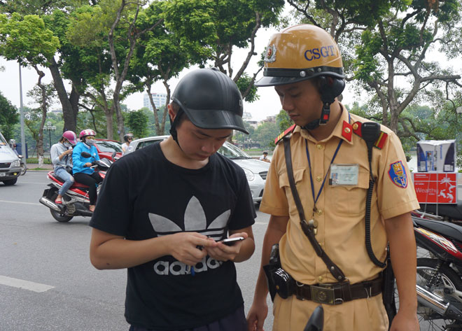 Cảnh sát giao thông Hà Nội đã xử lý nhiều trường hợp vi phạm luật giao thông đường bộ vì mải chơi Pokemon Go. Ảnh: Nguyễn Bình