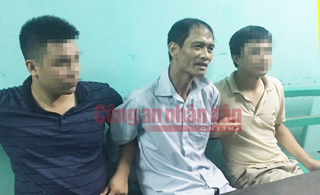 Tên sát nhân Doãn Trung Dũng (giữa) lúc bị bắt.
