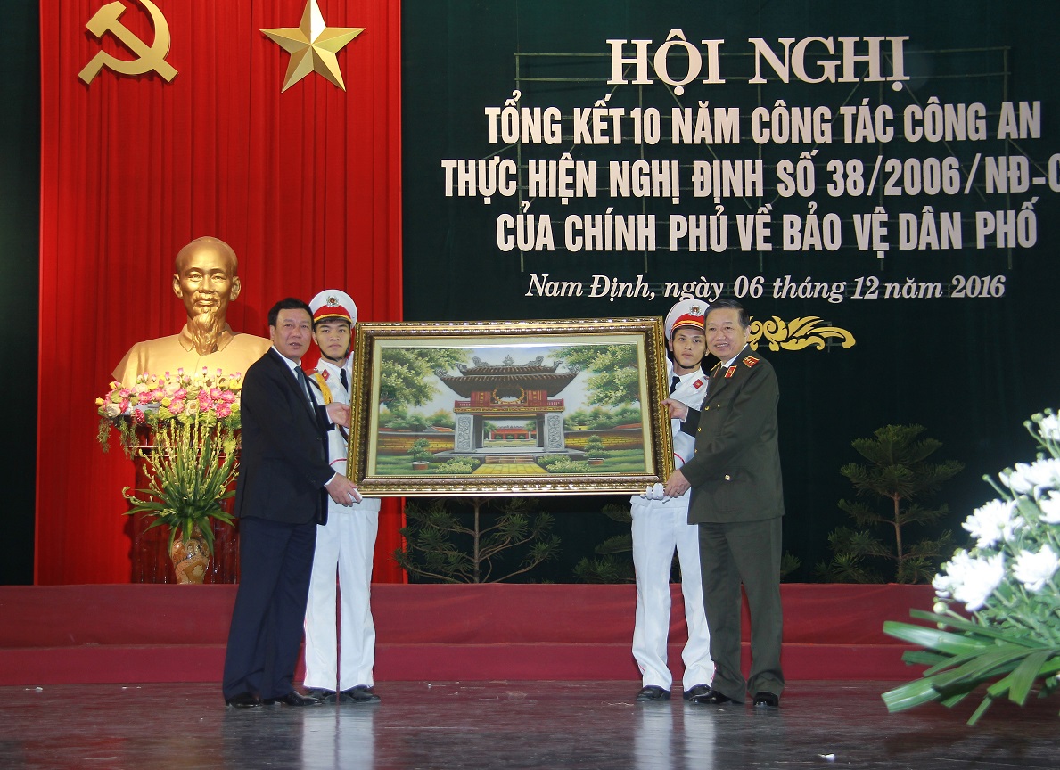 Bộ trưởng Tô Lâm trao quà lưu niệm của Bộ Công an tặng tỉnh Nam Định, đơn vị thực hiện tốt Nghị định số 38 của Chính phủ.