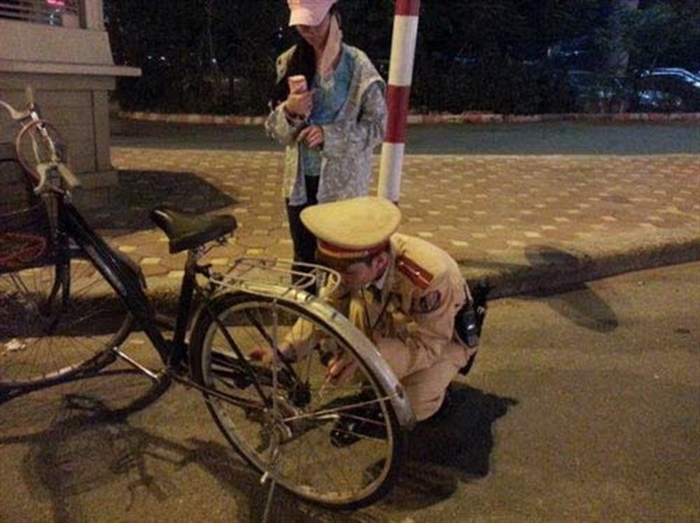 Ảnh Cảnh sát giao thông và hành động đẹp sửa xe giúp người đi đường.