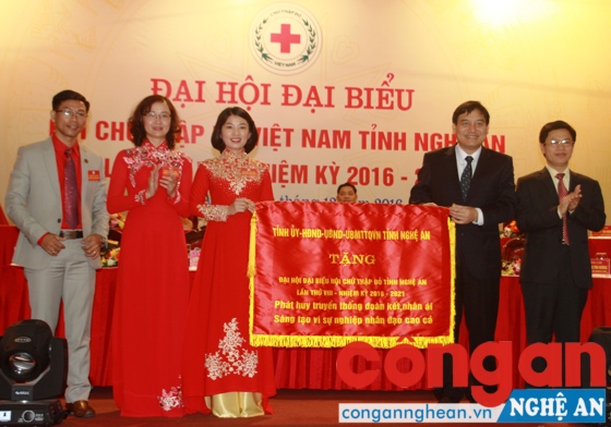 Đồng chí Nguyễn Đắc Vinh, Ủy viên Ban chấp hành Trung ương Đảng, Bí thư Tỉnh ủy và đồng chí Nguyễn Xuân Sơn, Phó Bí thư Thuường trực Tỉnh ủy, Chủ tịch HĐND tỉnh trao tặng bức trướng của tỉnh cho Hội Chữ thập đỏ tỉnh.