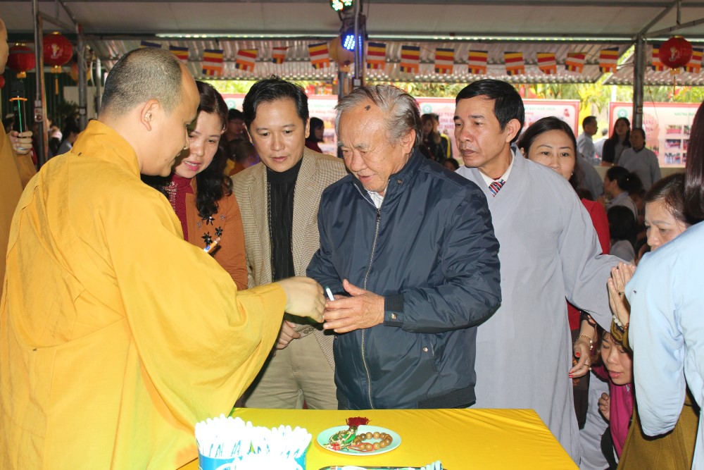 Tặng bút cho người dân tham gia hành lễ