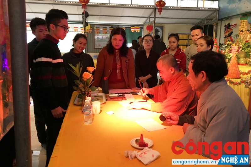 Nhiều người xếp hàng giữ trật tự xin chữ đầu năm tại lễ khai bút ở chùa Đức Hậu (xã Nghi Đức, TP Vinh) vào mồng 7 Tết Đinh Dậu 2017