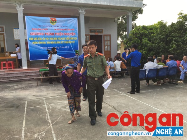 CBCS Công an huyện Thanh Chương ân cần dìu người cao tuổi vào khu vực khám, chữa bệnh và phát thuốc miễn phí