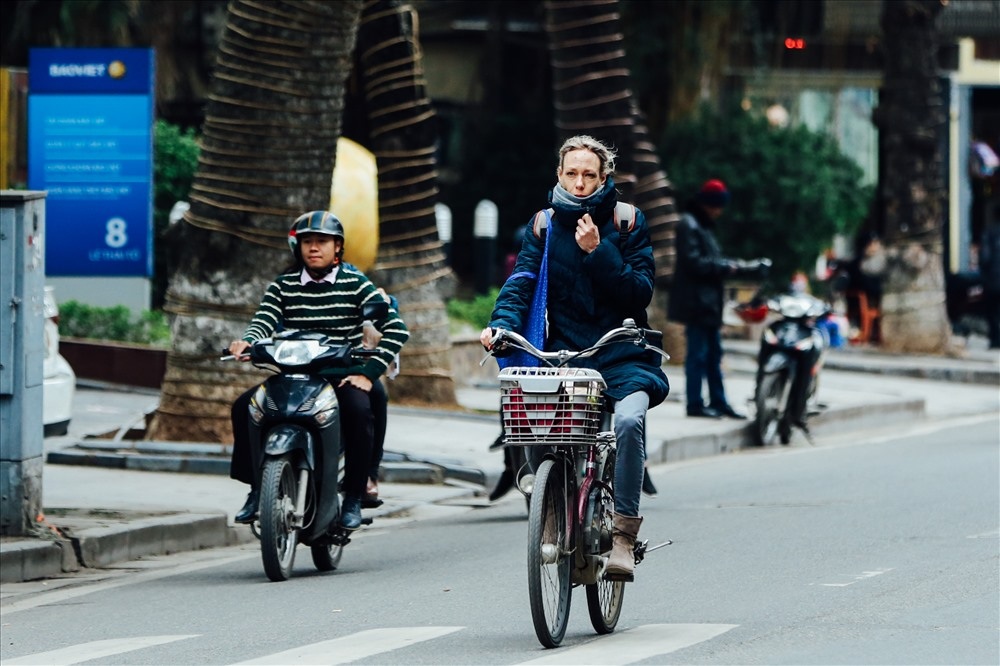 u khách nước ngoài túm cổ áo để tránh gió lạnh lùa vào người. (Ảnh: Báo Lao động)