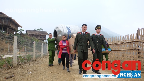 Các CBCS Công an huyện Nam Đàn đang vác những tẹc nước lên cho đồng bào nơi đây