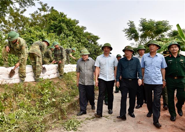 Phó Thủ tướng Trịnh Đình Dũng cùng Bí thư Tỉnh ủy Quảng Ninh Nguyễn Văn Đọc, Chủ tịch UBND tỉnh Quảng Ninh Nguyễn Đức Long thị sát, đôn đốc, động viên lực lượng ứng phó Bão số 6 tại đê Hà Nam, huyện Quảng Yên, Quảng Ninh. Ảnh VGP/Nhật Bắc
