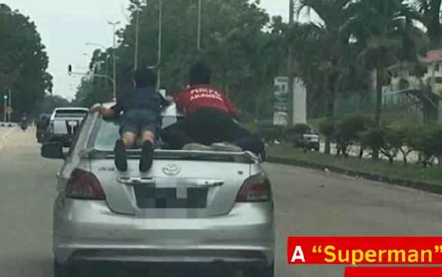 Người cha cho con bám trên đuôi xe chạy tốc độ cao