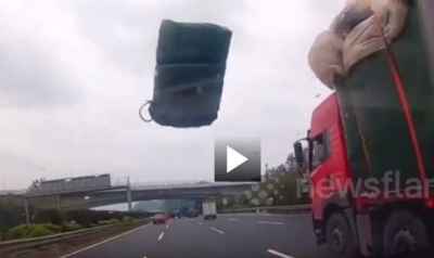 Tấm bạt bay bất ngờ từ xe tải, khiến tài xế xe con 'méo mặt'