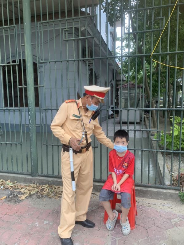 Cán bộ Cảnh sát giao thông Công an thành phố Vinh ra sức động viên, an ủi để trấn tĩnh tinh thần cháu bé.
