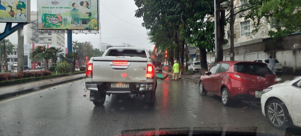 Sau khoảng 10 phút, cành cây được kéo vào vỉa hè, chờ công ty cây xanh đến thu dọn