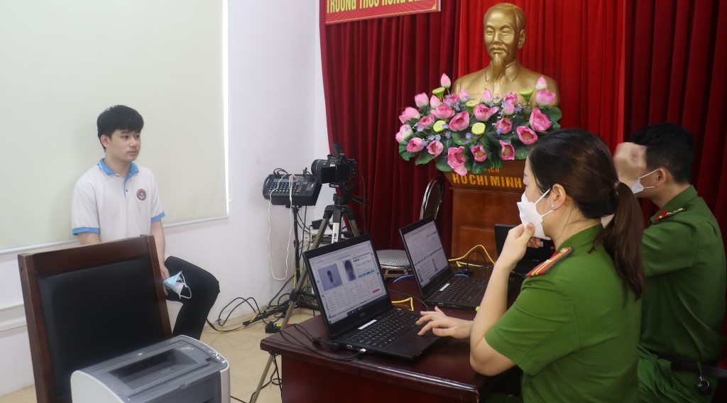 Cán bộ Công an thực hiện thao tác chụp ảnh cho học sinh đến làm thủ tục