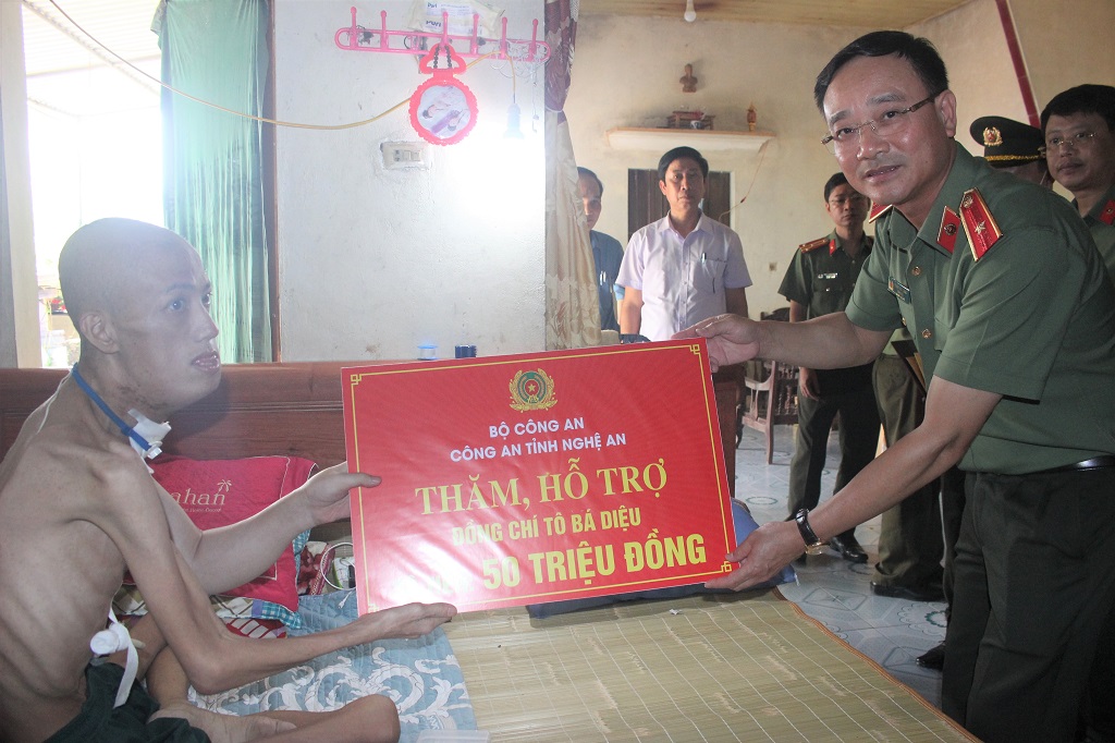 Đồng chí Thiếu tướng Phạm Thế Tùng, Giám đốc Công an tỉnh Nghệ An trao số tiền 50 triệu đồng của Công an tỉnh Nghệ An hỗ trợ đồng chí Diệu