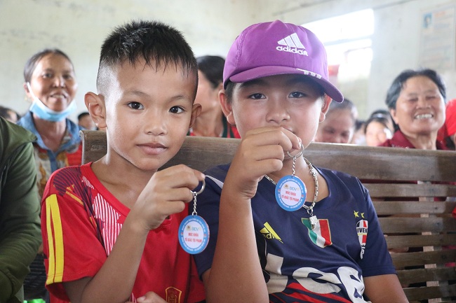 Hai em nhỏ được tặng móc khóa sau khi trả lời đúng các câu hỏi tìm hiểu về các loại ma túy