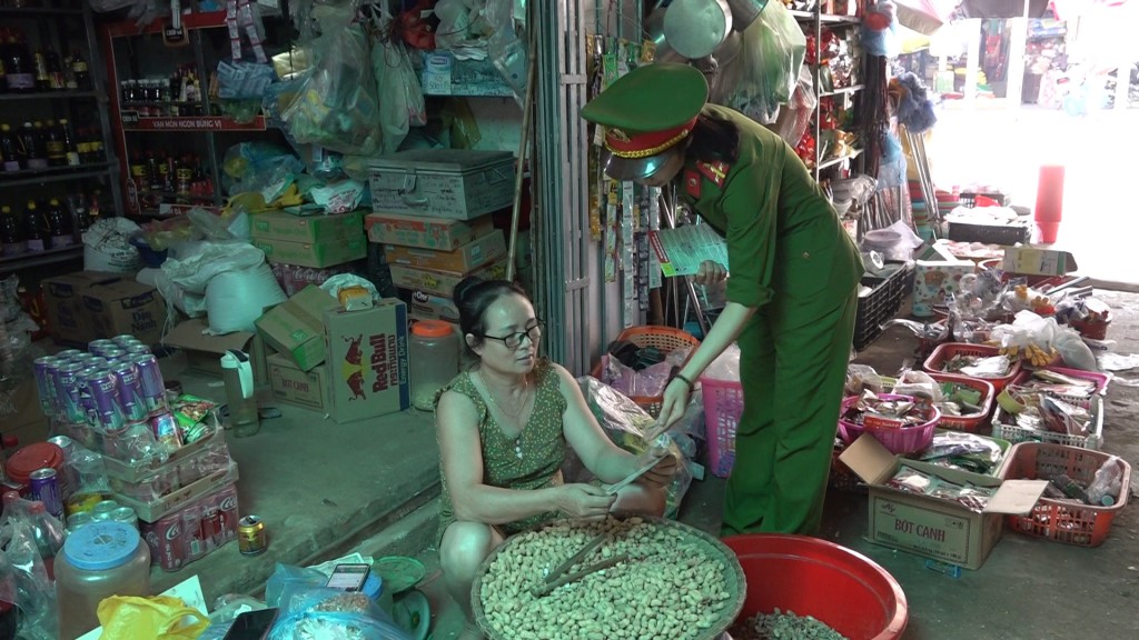 Các cán bộ tuyên truyền cho người dân ở chợ xã Nghĩa Đồng, huyện Tân Kỳ  