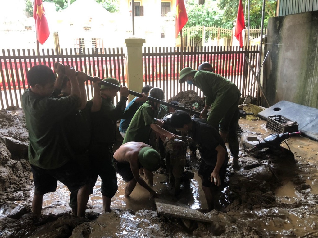 Lực lượng Công an giúp người dân đưa phương tiện ra khỏi nơi ngập lụt