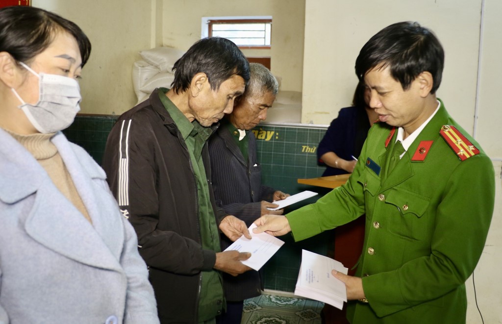 Đại diện lãnh đạo Công an huyện Hưng Nguyên trao quà tặng bà con Nhân dân