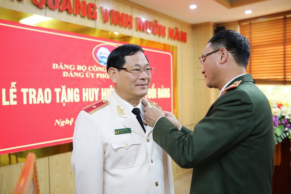 Đồng chí Thiếu tướng Phạm Thế Tùng - Ủy viên Ban Thường vụ Tỉnh ủy, Bí thư Đảng ủy, Giám đốc Công an tỉnh trao quyết định và gắn huy hiệu 40 năm tuổi Đảng tặng đồng chí Thiếu tướng Nguyễn Hữu Cầu