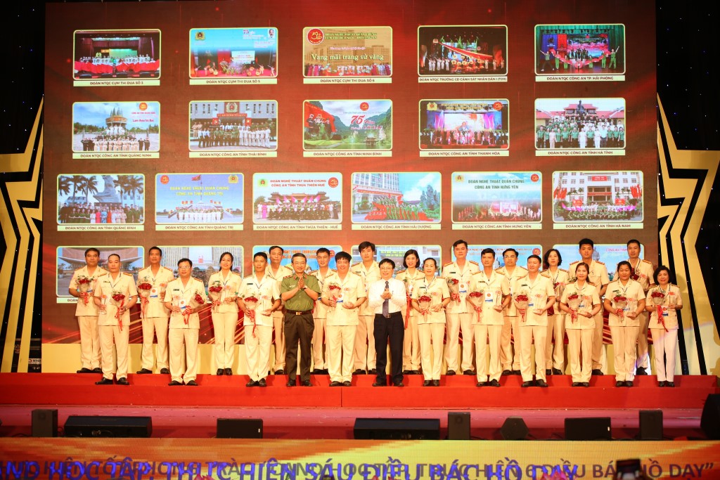 Trung tướng Nguyễn Ngọc Toàn và Phó Chủ tịch UBND tỉnh Bùi Đình Long tặng hoa và biểu trưng cho đại diện các đoàn nghệ thuật quần chúng