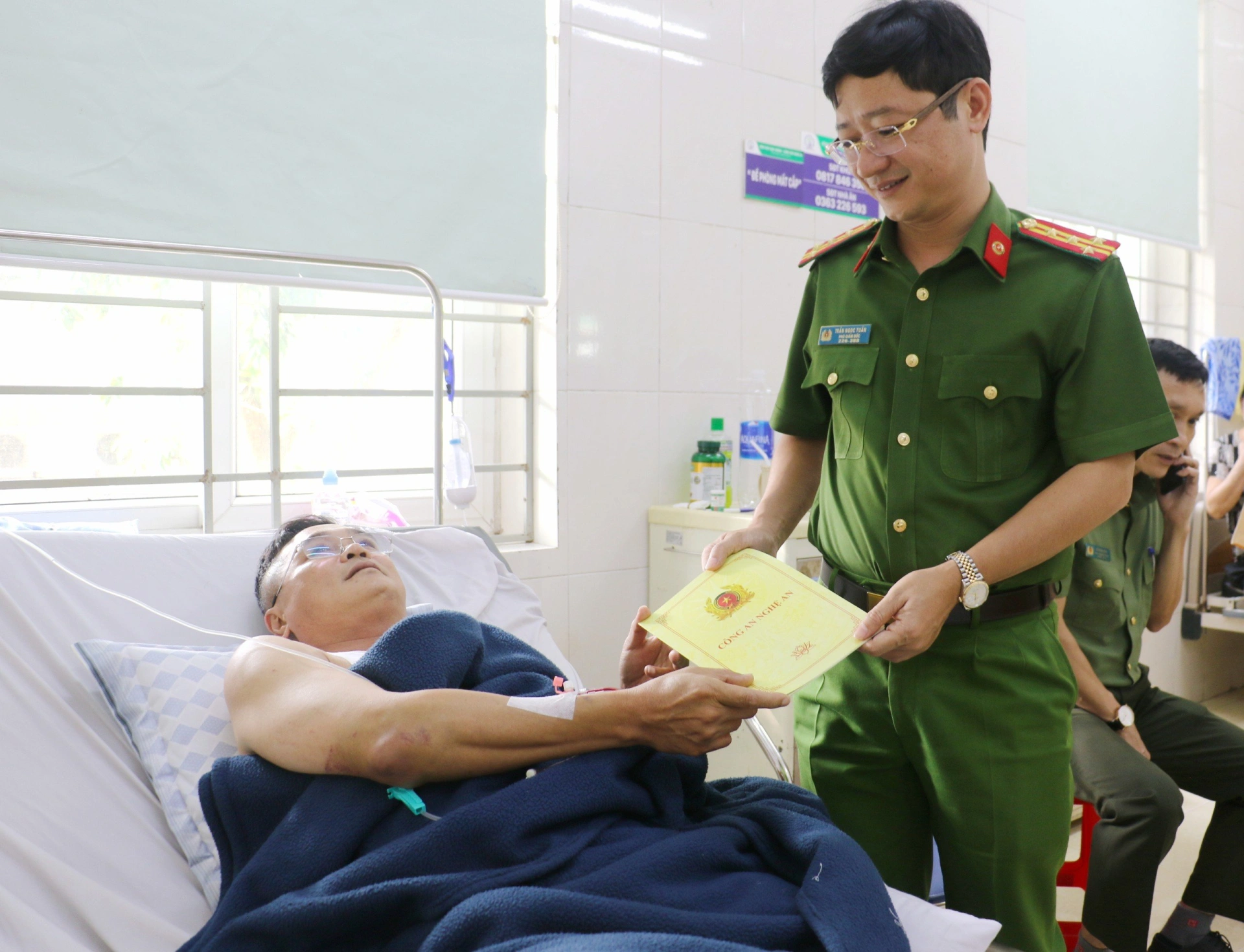Đồng chí Đại tá Trần Ngọc Tuấn chia sẻ, động viên và tặng quà Trung tá Hoàng Quang Vinh sớm bình phục
