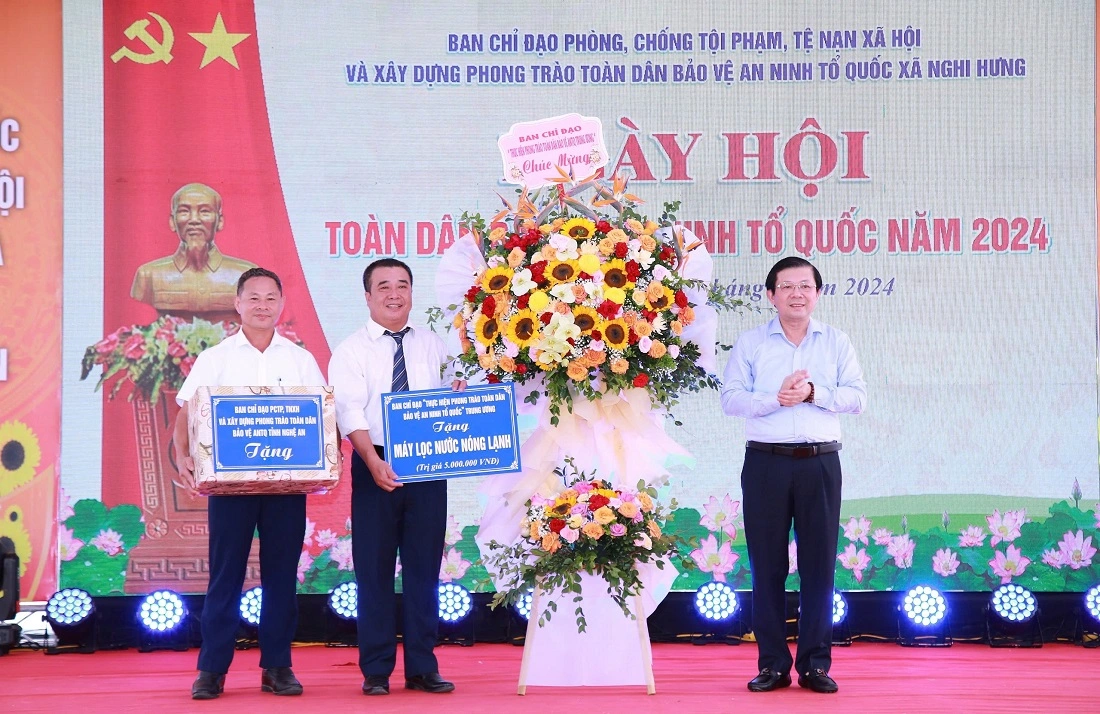 Đồng chí Nguyễn Hữu Dũng - Phó Chủ tịch Ủy ban Trung ương Mặt trận Tổ quốc Việt Nam tặng hoa và quà chúc mừng cán bộ, Nhân dân xã Nghi Hưng