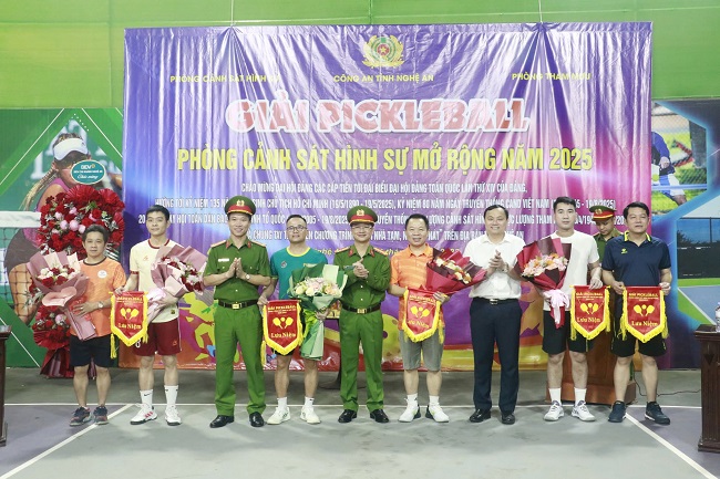 Các đồng chí: Đại tá Trần Ngọc Tuấn, Phó Giám đốc Công an tỉnh; Phạm Ngọc Cảnh, Phó Trưởng Ban Tuyên giáo và Dân vận Tỉnh ủy tặng hoa và cờ lưu niệm cho đại diện các Đội tham gia thi đấu