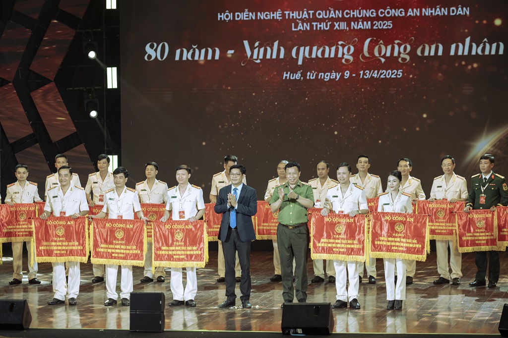 Thiếu tướng Nguyễn Công Bẩy và Phó Chủ tịch UBND TP Huế Nguyễn Chí Tài trao Cờ của Bộ Công an tặng 05 đơn vị đạt chương trình nghệ thuật xuất sắc (Công an Nghệ An thứ hai từ phải sang)