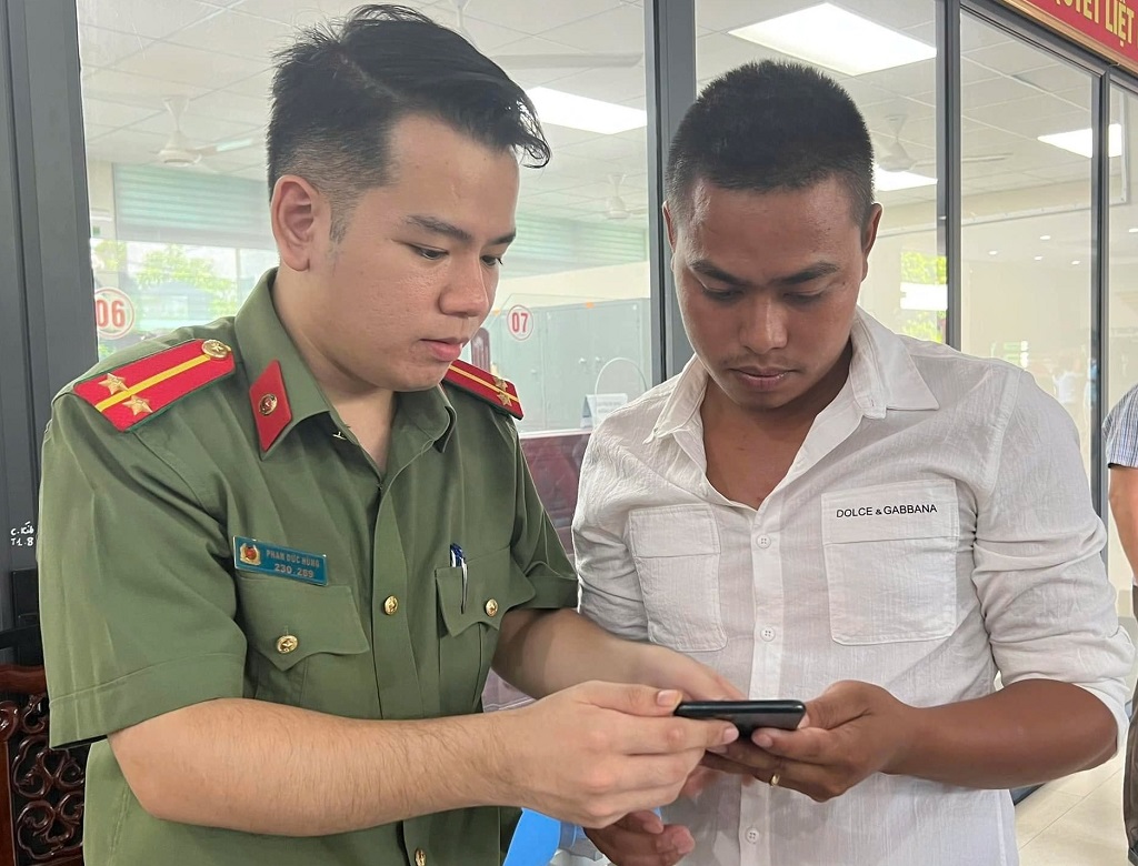 Cán bộ Phòng Quản lý xuất, nhập cảnh hướng dẫn người dân làm hộ chiếu trực tuyến