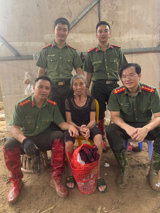 Cán bộ, chiến sĩ Công an tỉnh Nghệ An chụp ảnh cùng bà Trần Thị Thìn , khối 5, xã Mường Xén (sau khi dọn dẹp bùn đất cho gia đình bà Thìn)