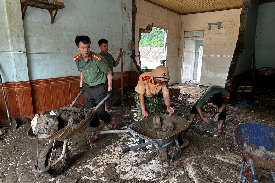 Lực lượng Công an hỗ trợ người dân nạo vét bùn đất trong nhà tại xã Mường Xén