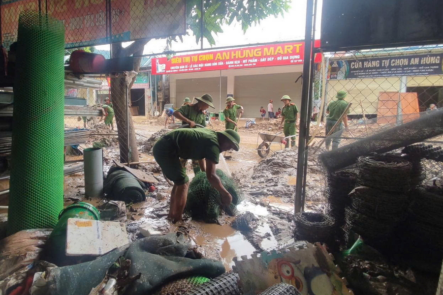 Lực lượng Công an hỗ trợ người dân nạo vét bùn đất trong nhà dân, khơi thông dòng chảy tại xã Hữu Kiệm 