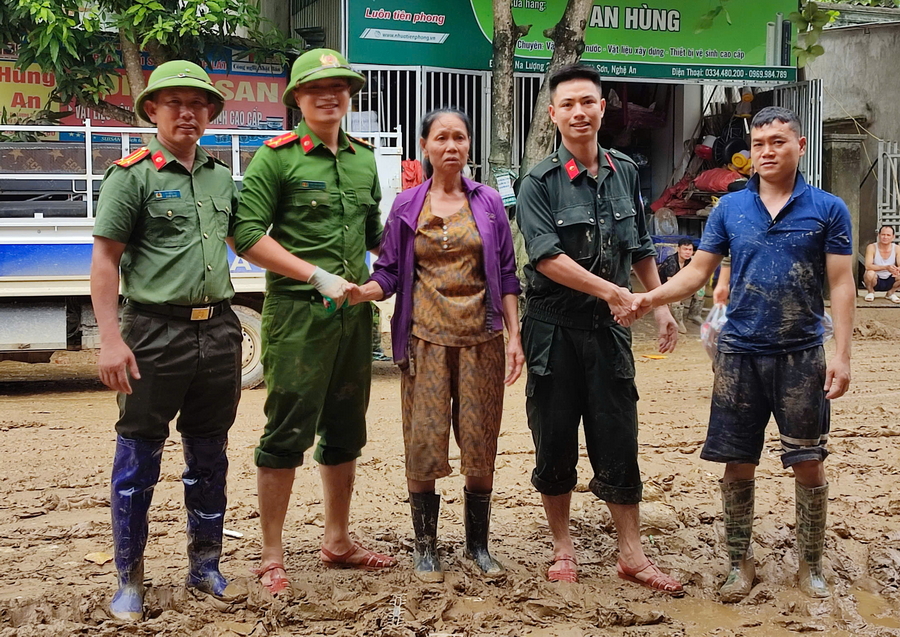 Tổ công tác Công an Nghệ An hỗ trợ gia đình bà Nguyễn Thị An, trú tại bản Na Lượng 2, xã Hữu Kiệm dọn dẹp bùn đất sau lũ cuốn (Trong ảnh: Sau khi được Tổ công tác dọn dẹp xong, gia đình bà An xúc động, bắt tay cảm ơn cán bộ, chiến sĩ)